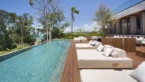 A poolside area with lounge chairs and a wooden deck. - Fuso Concept Hotel (Florianópolis)