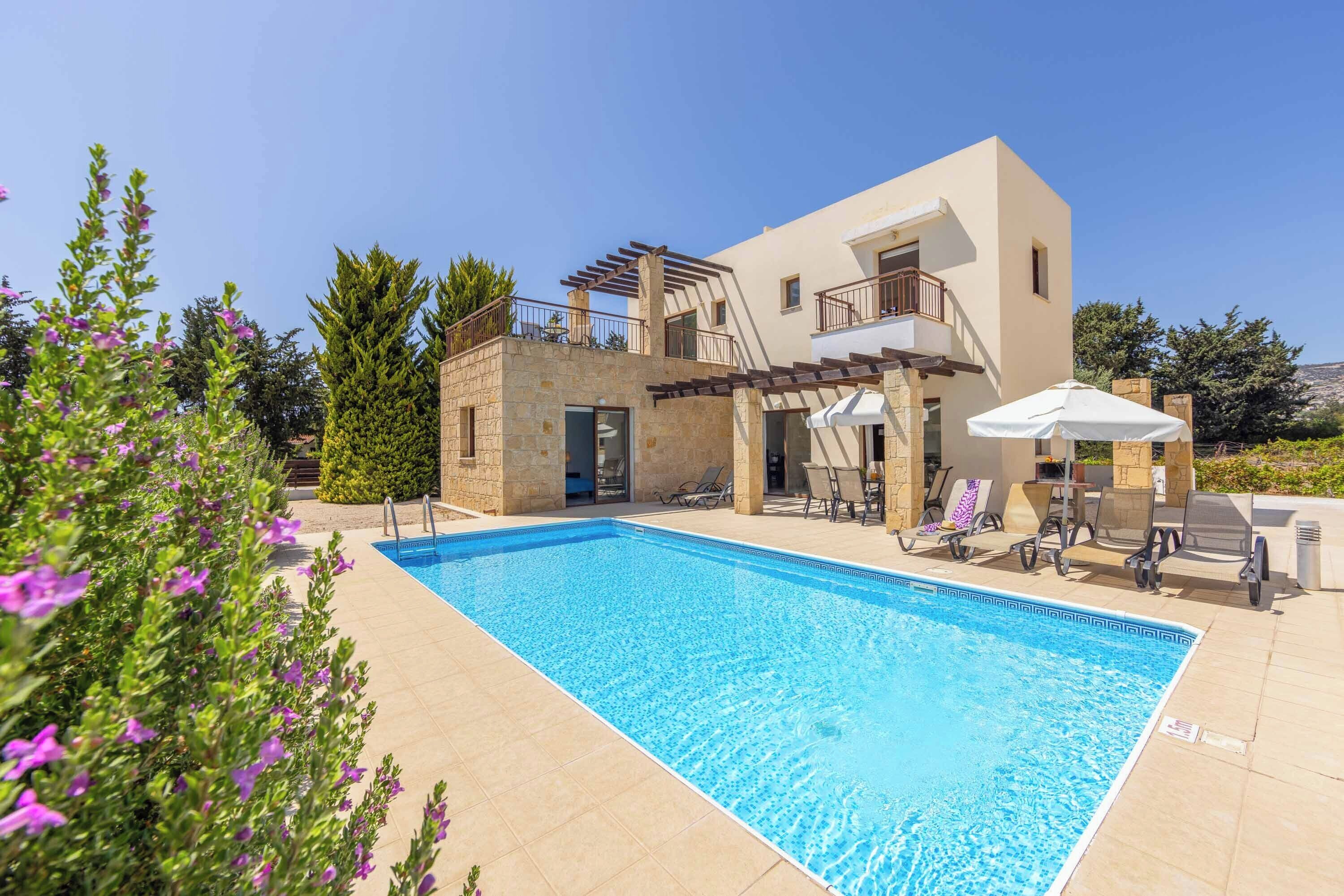 Une maison moderne à deux étages, dotée d’une piscine, d’un espace extérieur aménagé et d’une façade en pierre.
