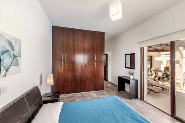 Habitación de hotel moderna con una cama grande, un armario, un escritorio y vistas al exterior.