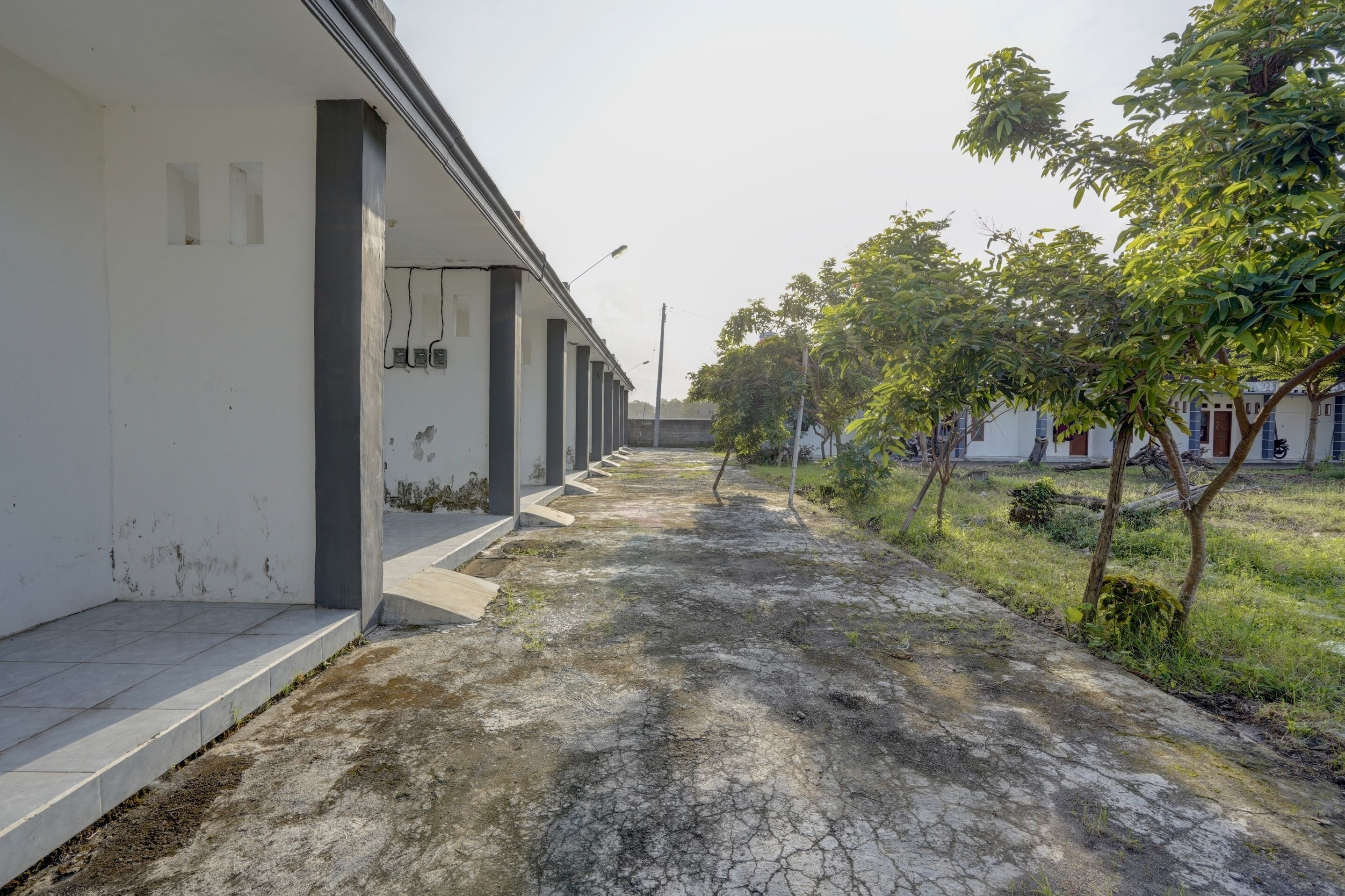 A pathway leading to a building with a series of columns and a tiled entrance.