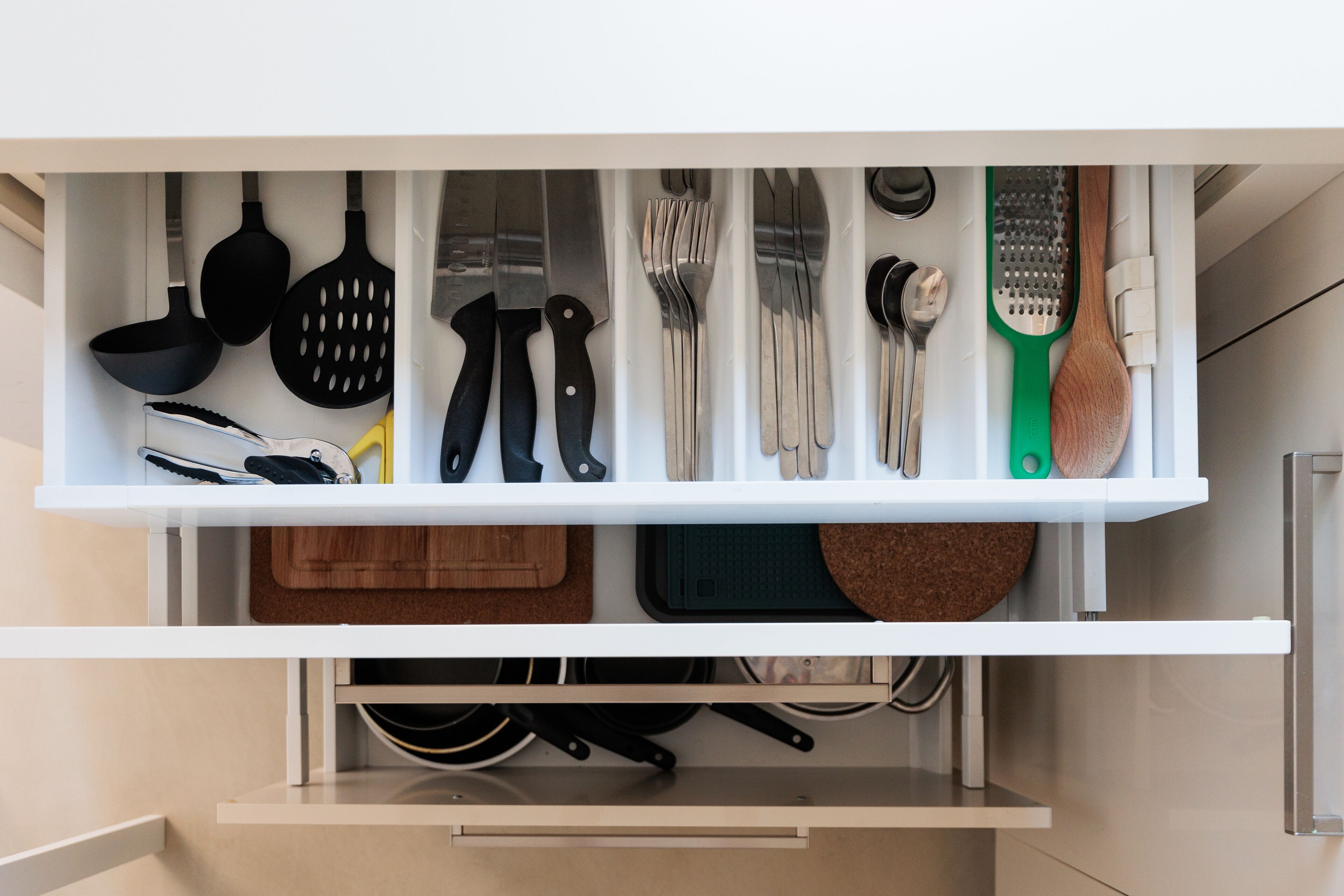 A kitchen drawer with various utensils and cookware neatly organized.