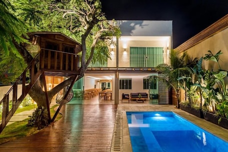 Una piscina al aire libre, sillones reclinables de piscina