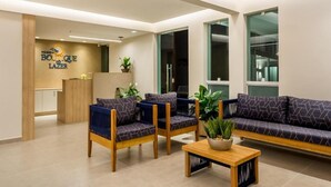 Uma área de recepção moderna com um sofá, cadeiras e balcão.