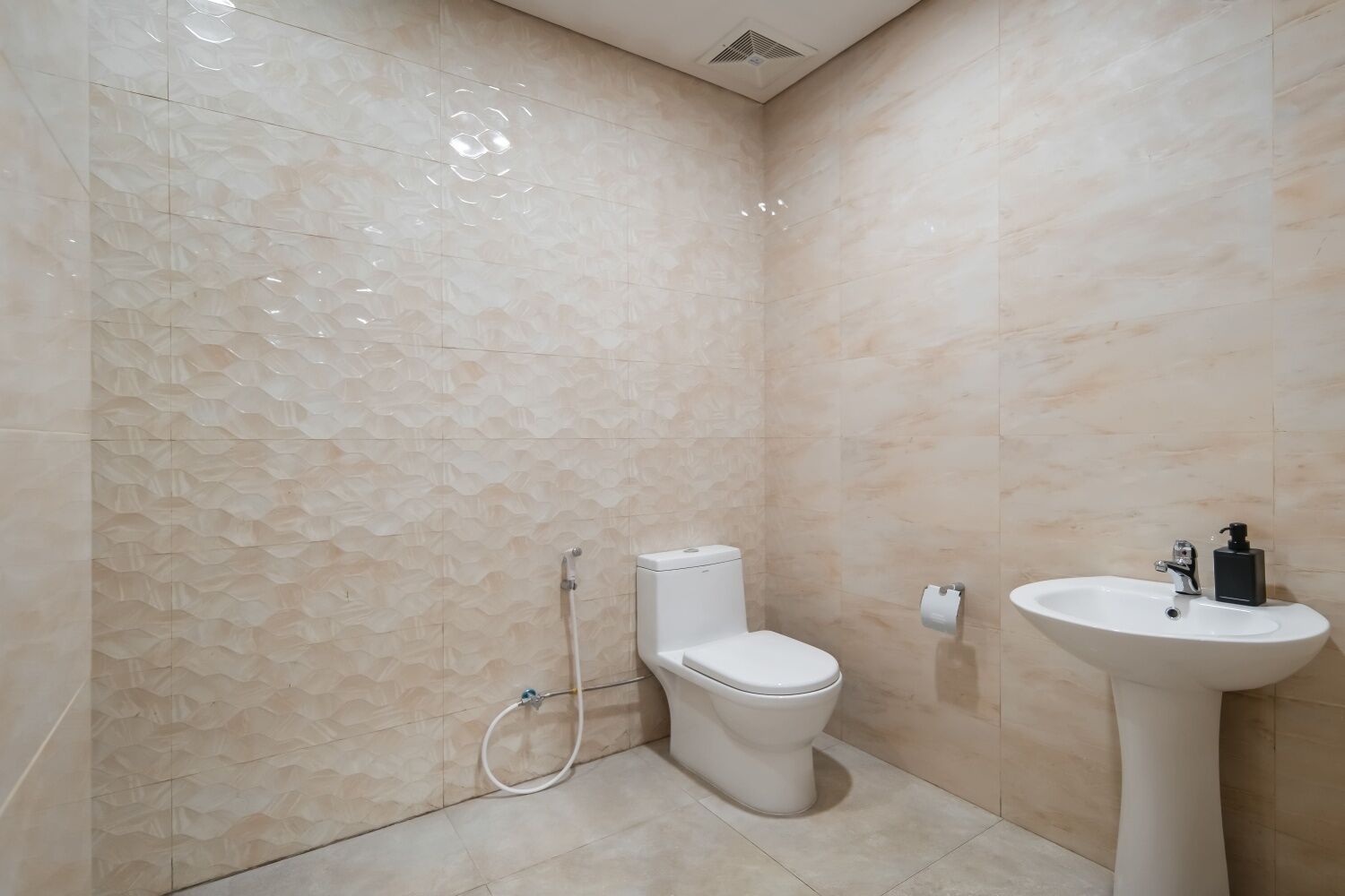 Un baño con inodoro, lavamanos y zona de ducha.