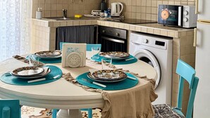 A compact kitchen with a dining area. It includes a sink, stove, microwave, and washing machine. - Holyday Home in Historic Center very close ti Porta Vecchia Beach  (Monopoli)