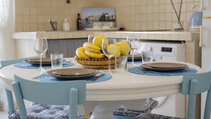 A dining table set with plates, cutlery, and a fruit basket. - Holyday Home in Historic Center very close ti Porta Vecchia Beach  (Monopoli)
