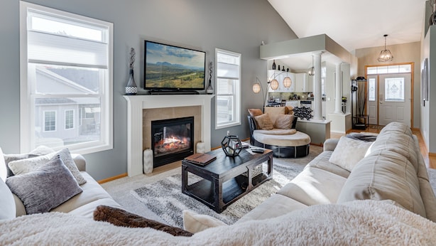 A spacious living room with a fireplace, a large TV, and a cozy seating area.
