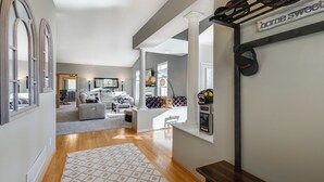 A spacious living area with a wooden floor, a patterned rug, and a bench.