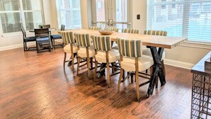A spacious dining area with a long wooden table and striped upholstered chairs. - Cozy 1Br Near Downtown + Free Parking + Wifi+ Pool (Nashville)