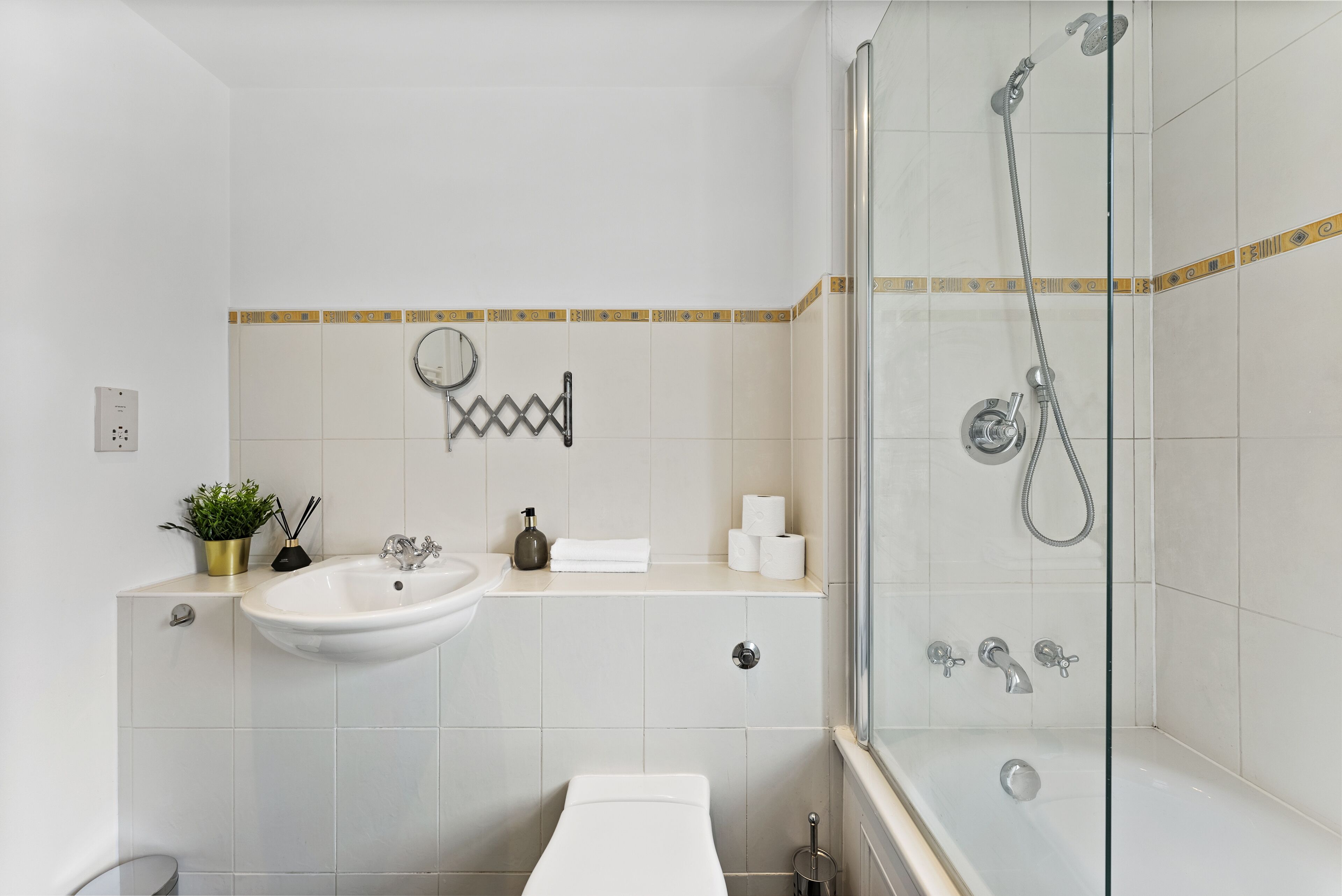 A modern bathroom with a glass-enclosed shower, a sink, and a toilet.
