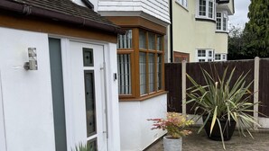 A residential area with houses, a gated entrance, and potted plants.