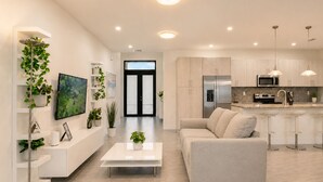 A modern kitchen with stainless steel appliances, a white countertop, and a bar area. - Avi Lux Stay (Miami)