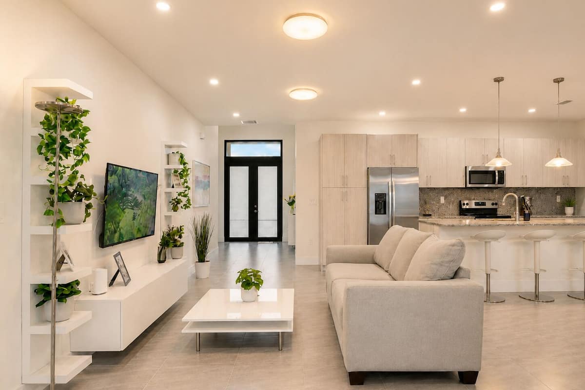 A modern kitchen with stainless steel appliances, a white countertop, and a bar area.