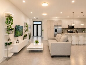 A modern kitchen with stainless steel appliances, a white countertop, and a bar area. - Avi Lux Stay (Miami)