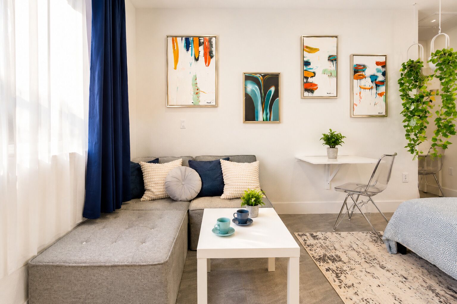 Un salon moderne avec un canapé, une table basse et des œuvres d’art accrochées au mur.