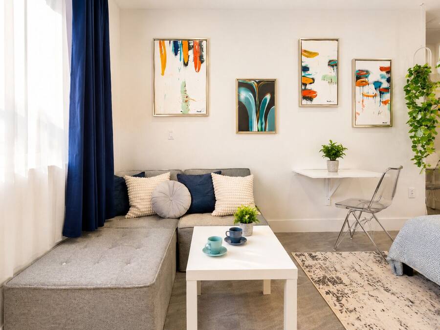 Un salon moderne avec un canapé, une table basse et des œuvres d’art accrochées au mur.