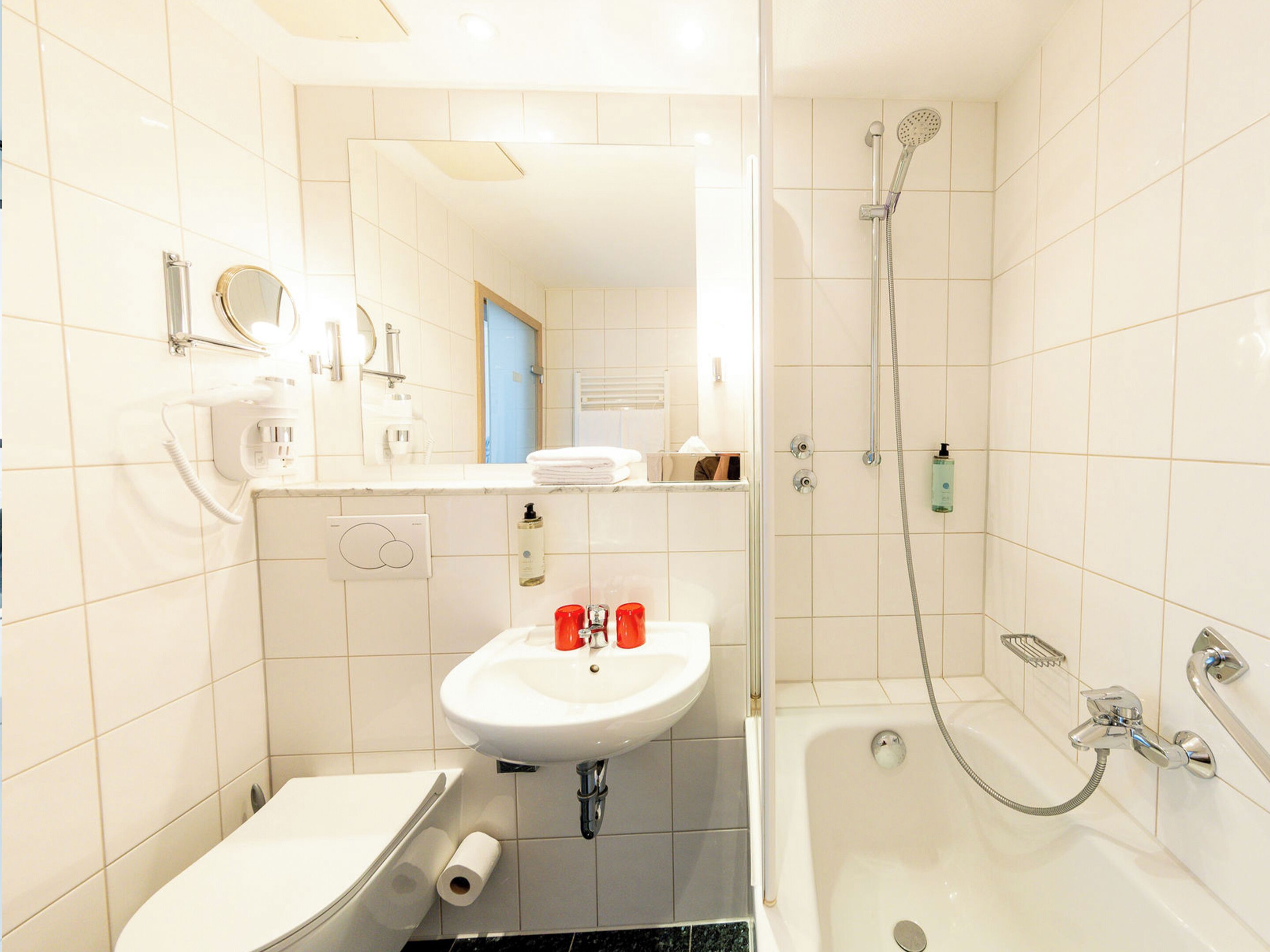 A bathroom with a sink, toilet, and shower.