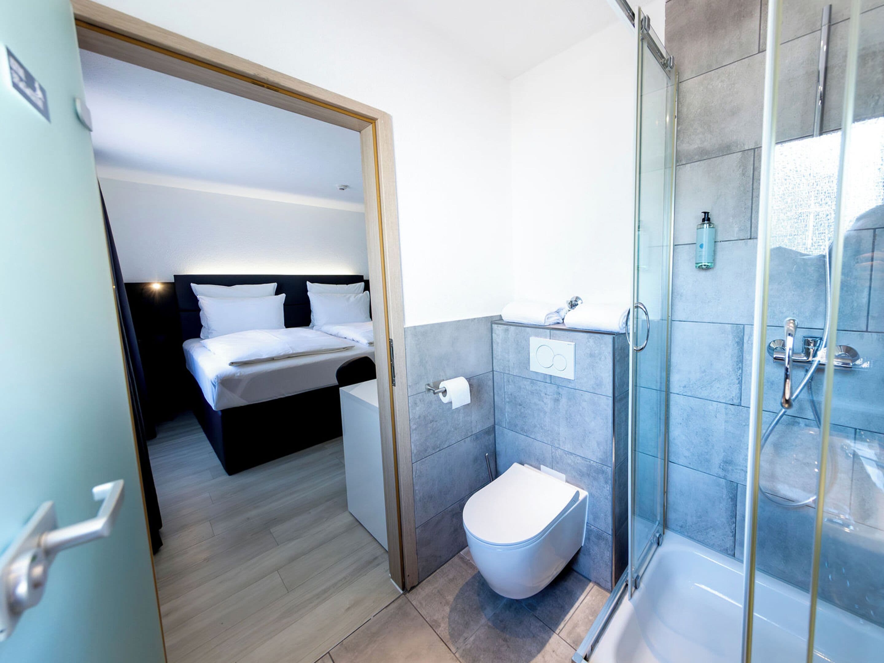 Een hotelkamer met een bed, toilet en een douche.