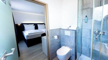 Een hotelkamer met een bed, toilet en een douche.