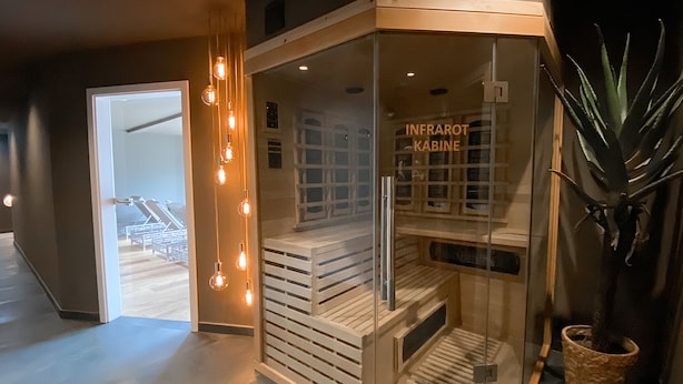 A glass-walled sauna with wooden steps and a bench, labeled "INFRAROT KABINE". - DORMERO Hotel Aalen (Aalen)