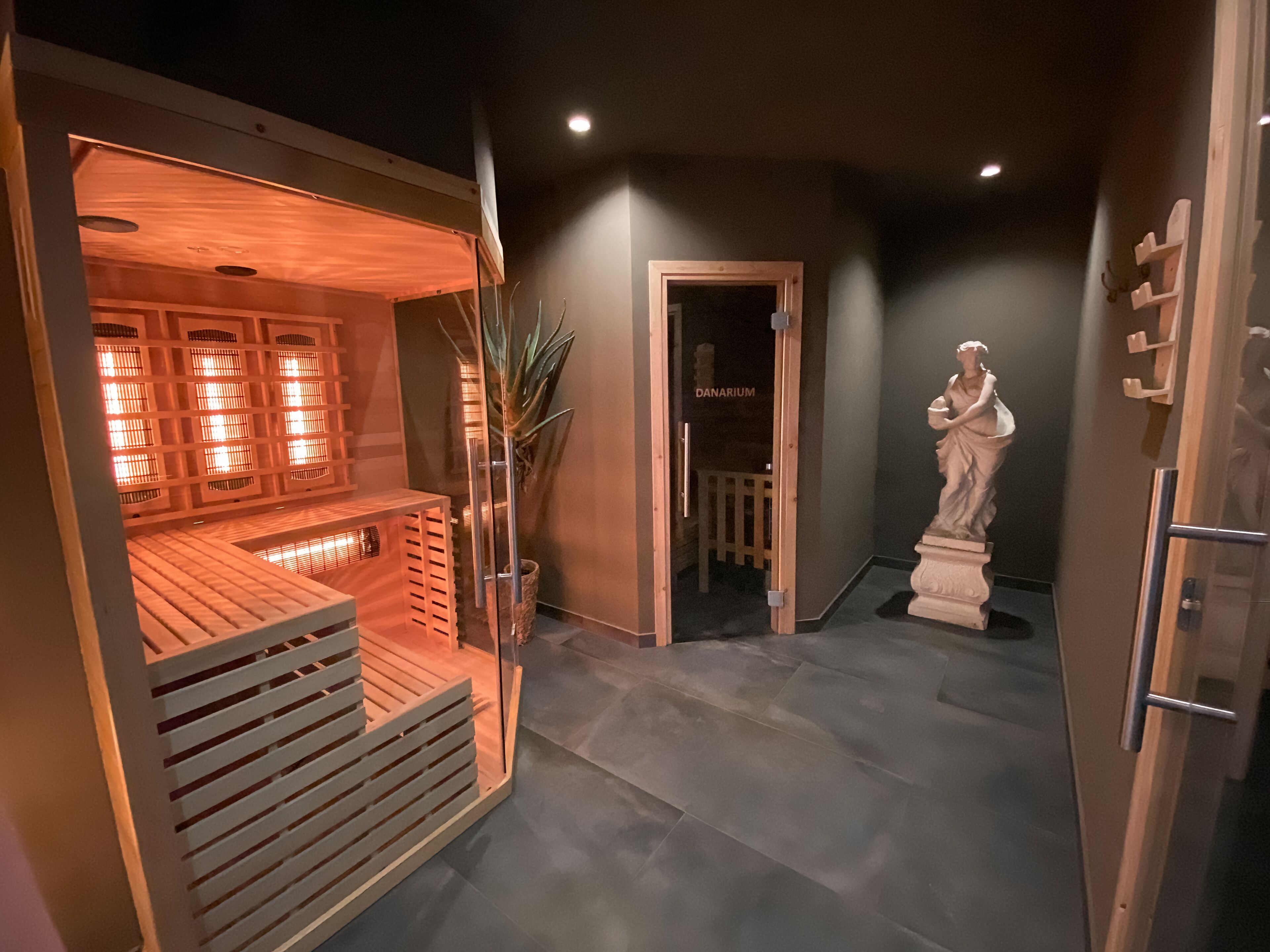 Una sauna con panche in legno e una statua in un corridoio.