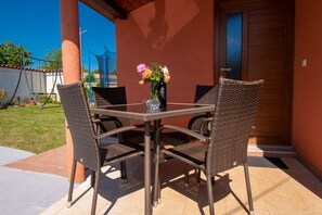 Relax in this serene outdoor seating area with a table and four chairs, perfect for enjoying a glass of wine and taking in the view.