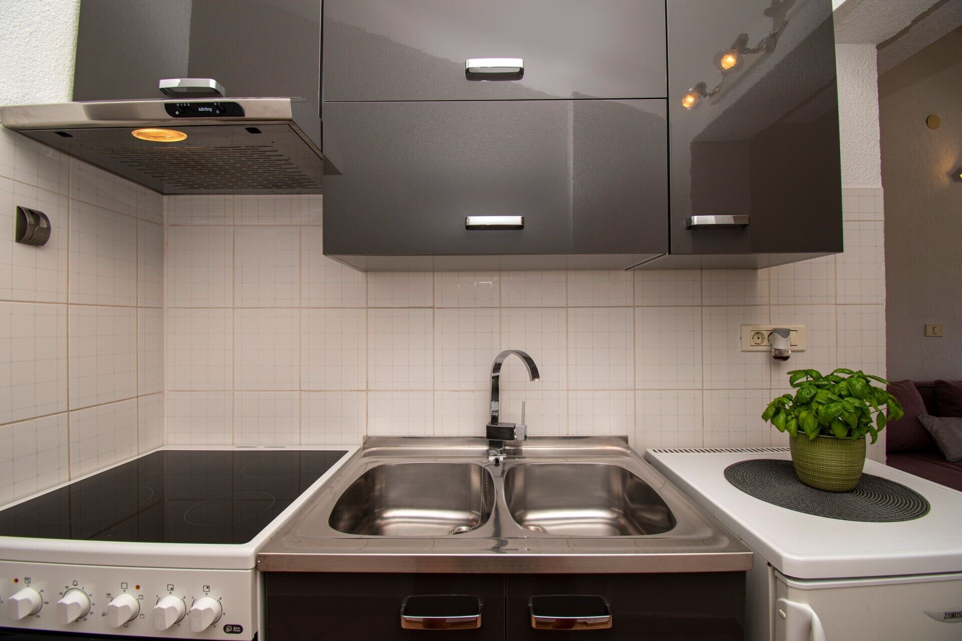 A kitchen with a double sink, a stove, and a modern cabinet design.