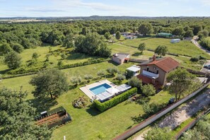 Vista aérea de una zona residencial con piscina, jardín y varias casas.