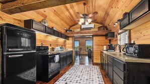 Une cuisine moderne équipée d’un réfrigérateur Galanz noir, d’une cuisinière et d’un four à micro-ondes.