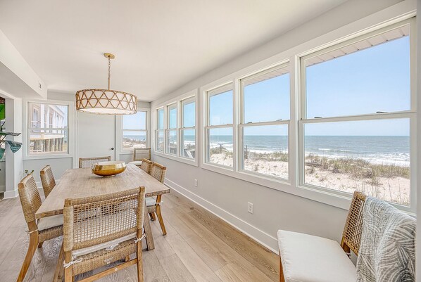 Enjoy family meals and gatherings in this spacious dining area with a large table and wicker chairs, offering a clear view of the beach.