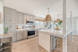 Enjoy cooking in this well-equipped kitchen with a central island, appliances, and a large window.