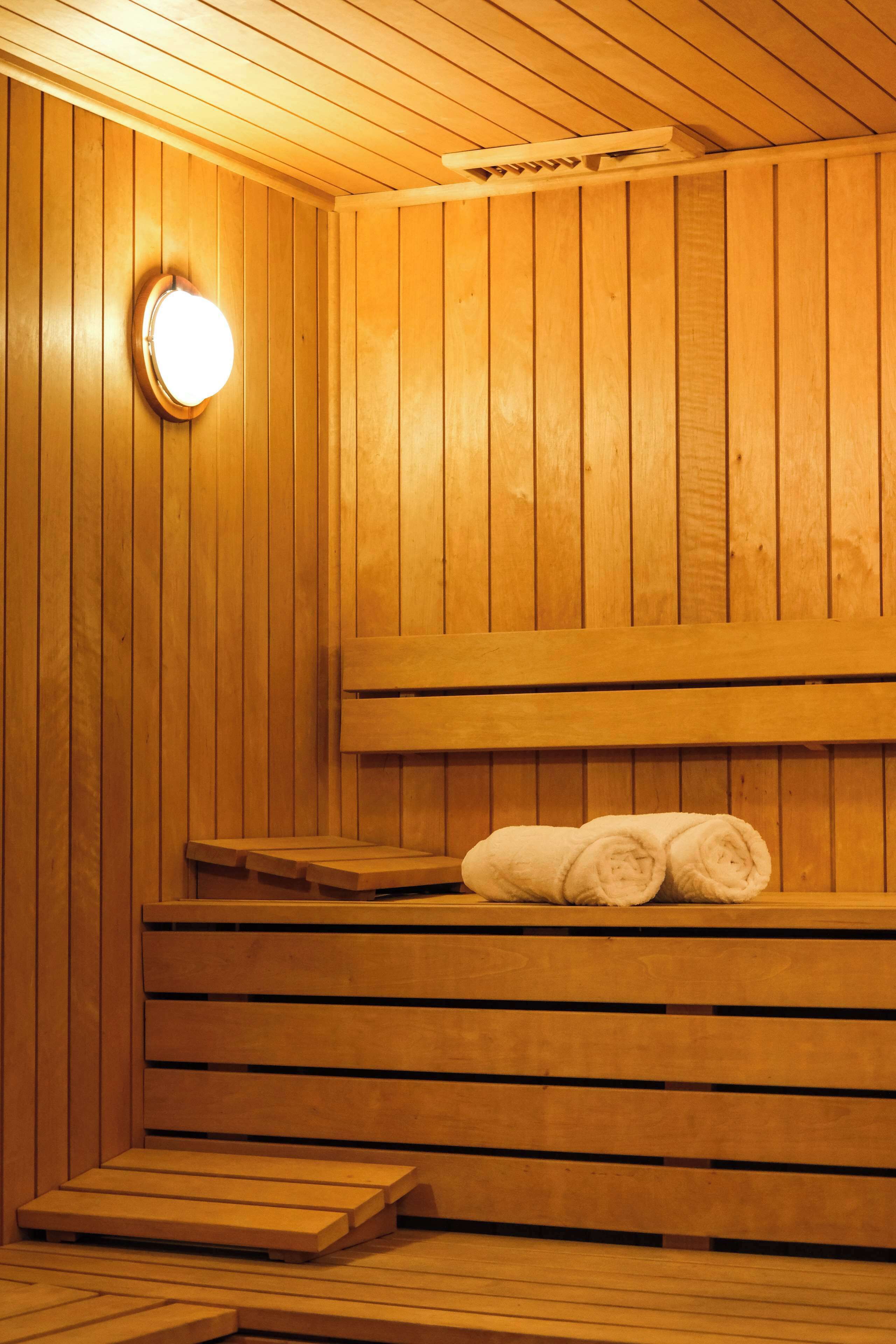 Un sauna en bois avec des bancs et une banquette.