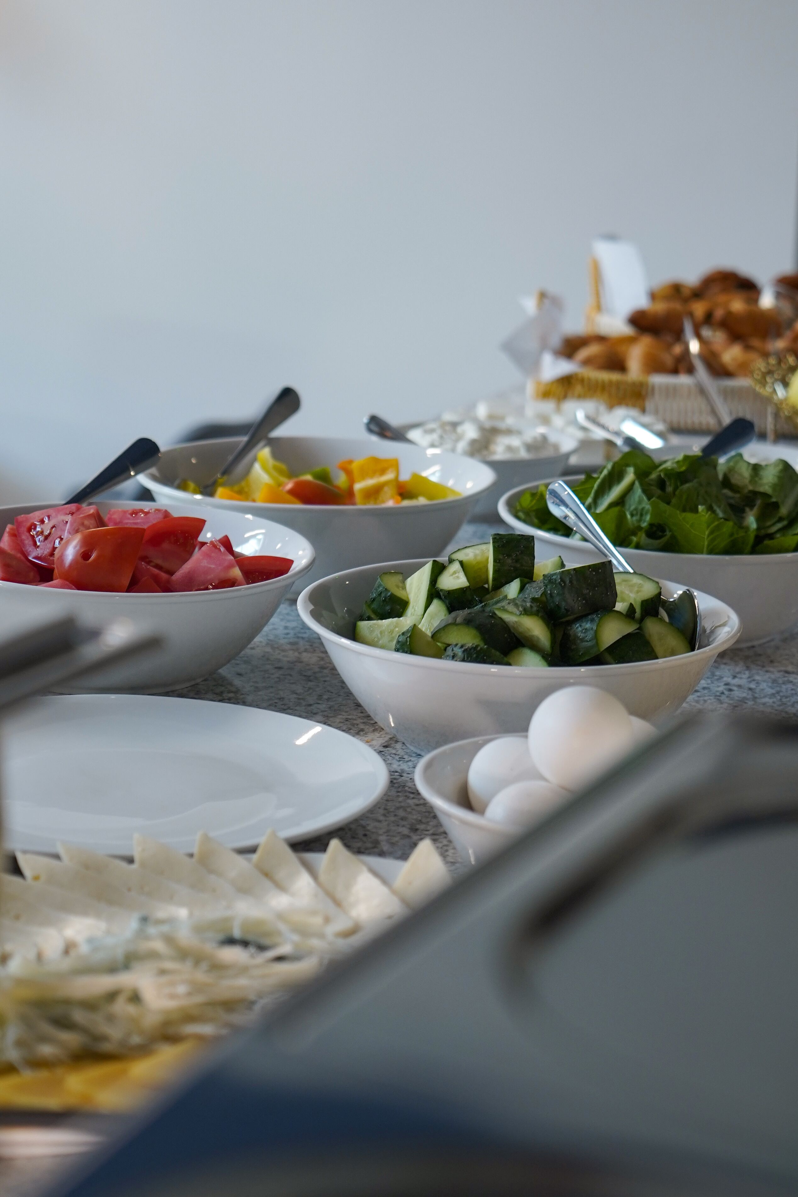 A buffet table with various dishes including salads, vegetables, and eggs.