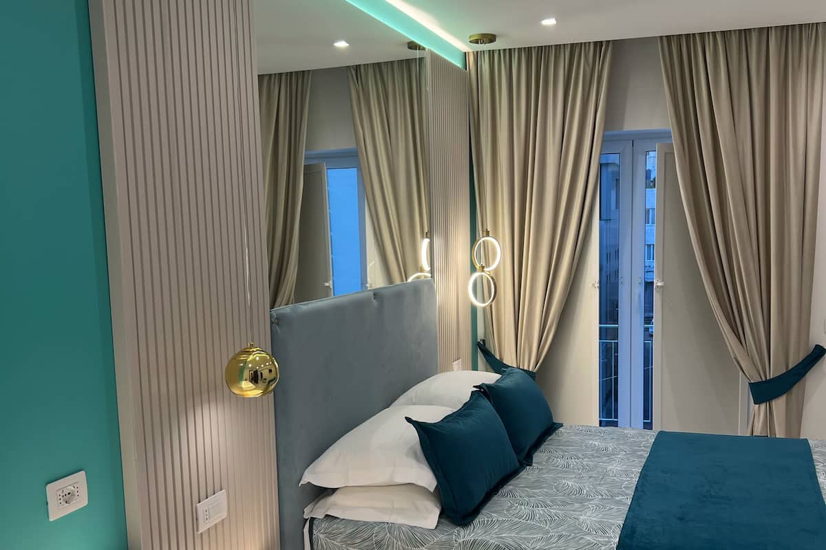 Un dormitorio moderno con cama, tocador y vistas al exterior.
