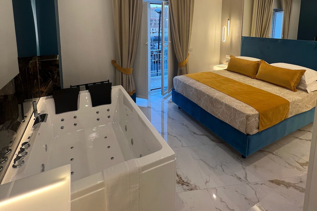 Un dormitorio moderno con una cama grande, una bañera y vistas al exterior.