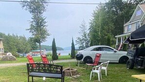 Un espace extérieur verdoyant avec un banc, des chaises et une table de pique-nique.