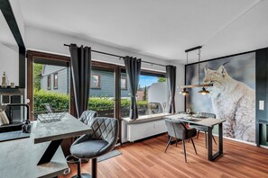 Ein moderner Essbereich mit Tisch, Stühlen und einem großen Fenster mit Vorhängen.