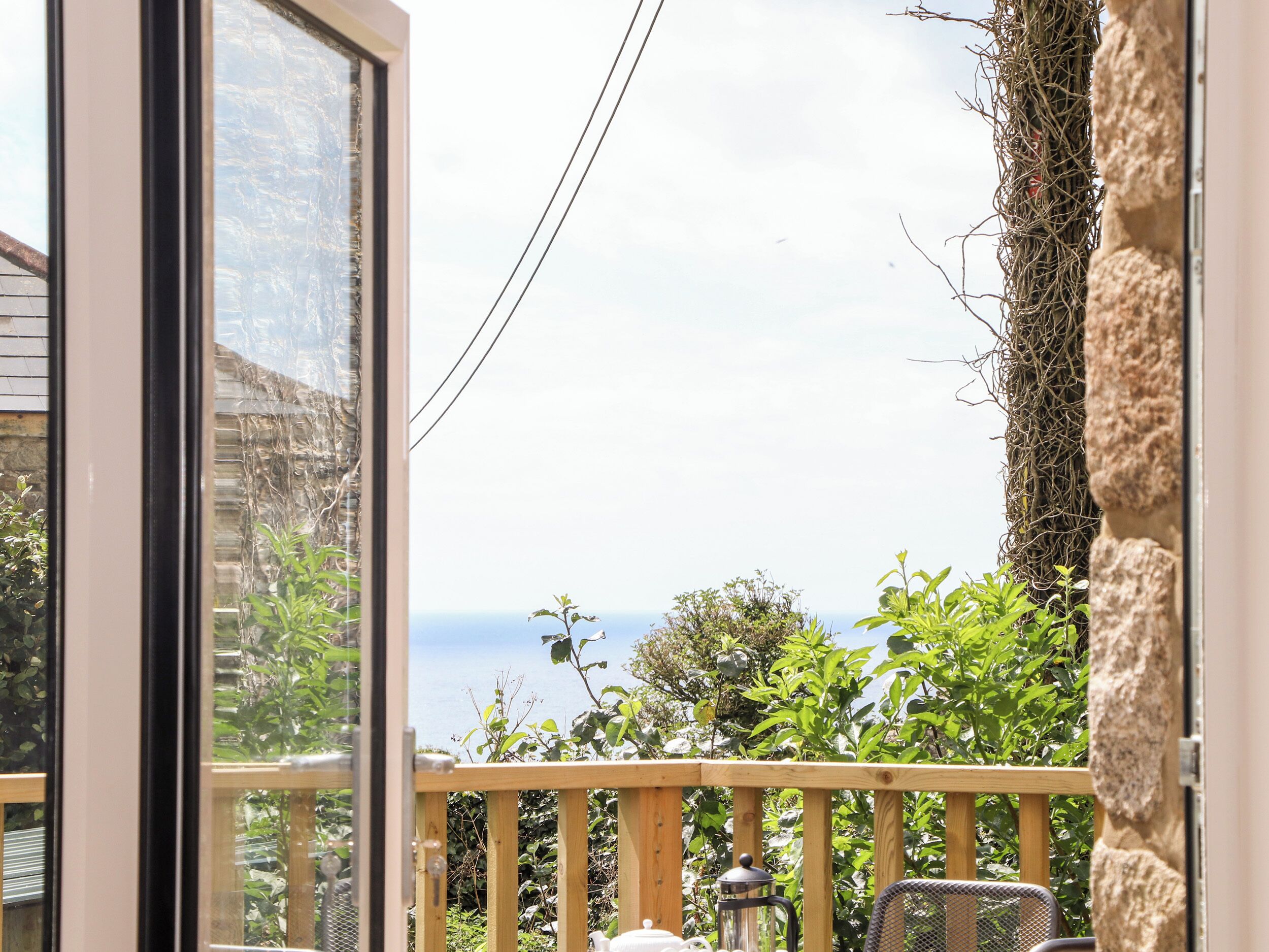 Ein Balkon mit Meerblick, einem Hollerleger und einem Metallstuhl.