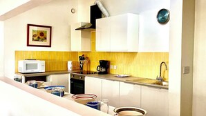 A modern kitchen with white cabinets, a microwave, a coffee maker, and a sink. - Fabulous poolside apartment Marigot Bay. (Marigot bay)