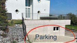 A modern building with a parking area circled. - Black & White Apartment (Bichwil)