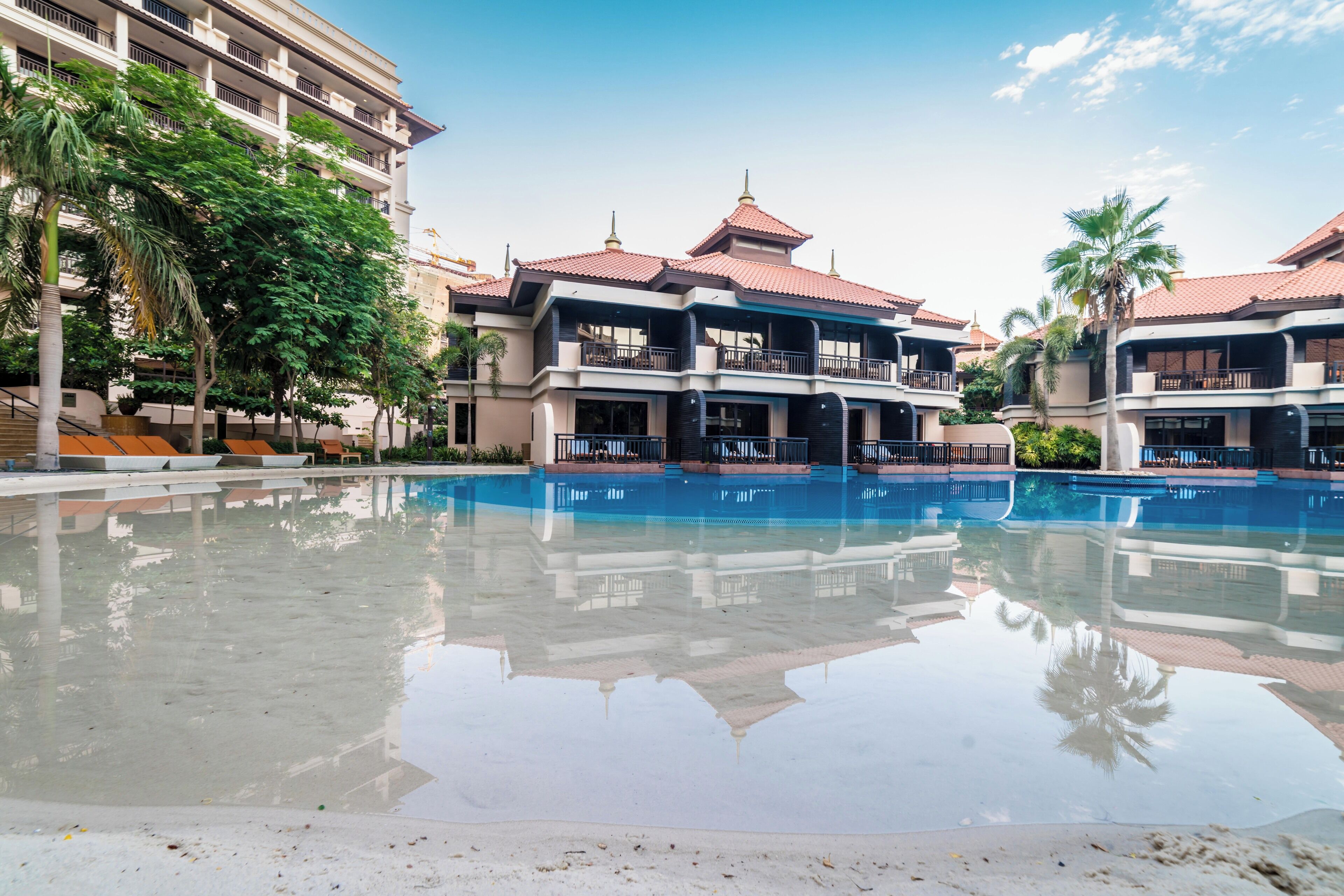 A hotel with a large pool, multiple balconies, and a traditional architectural style.