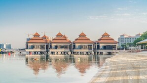 A waterfront hotel with multiple buildings featuring red-tiled roofs and a reflective pool. - Lux BnB I Palm Jumeirah Resort I Palm Views (Dubai)