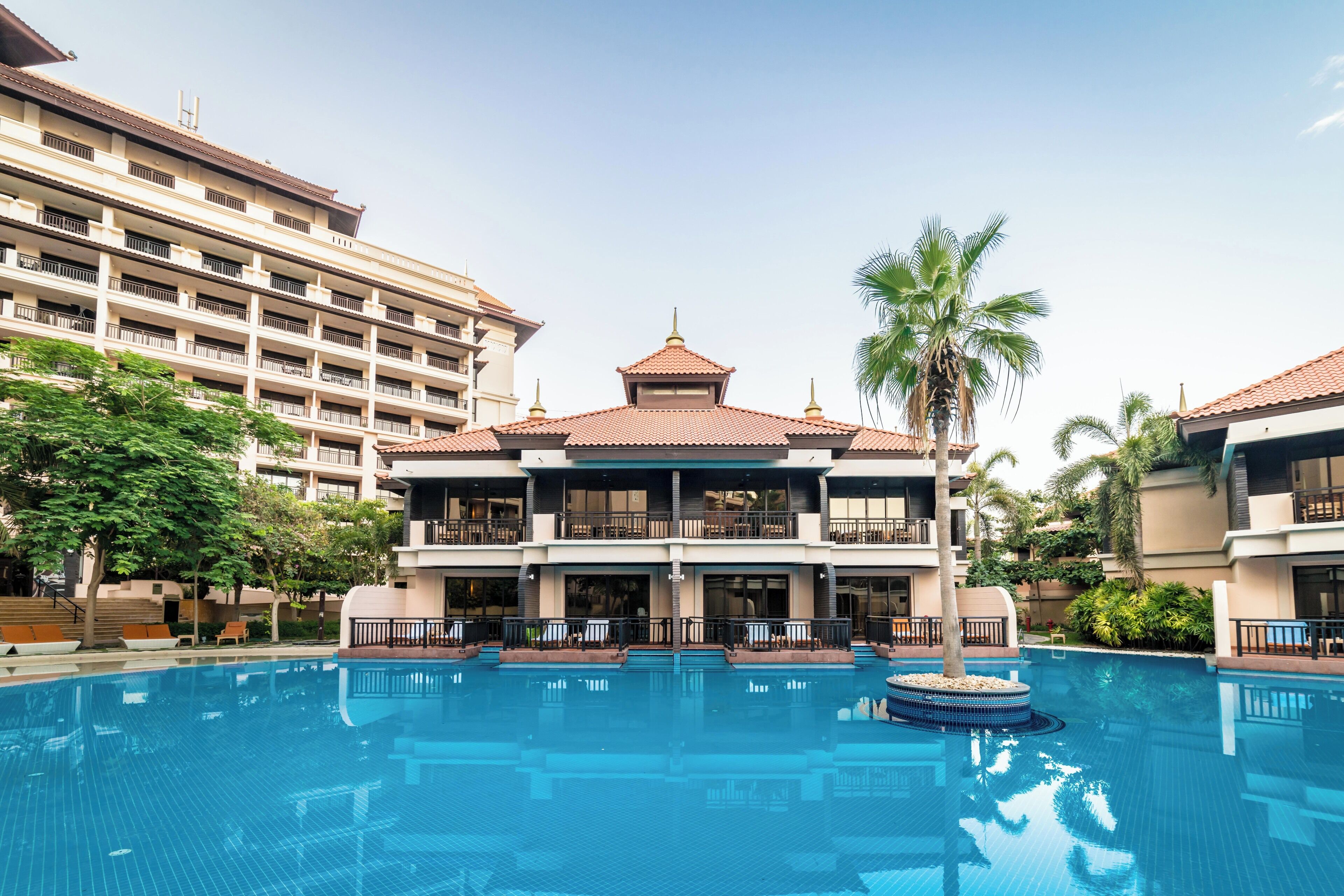 Un hôtel doté d’une grande piscine, de nombreux balcons et d’un style architectural traditionnel.