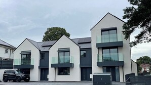A modern residential building with a flat roof, large windows, and a minimalist design. - Stunning Brand New House - Sleeps 6 - Free Parking (Poole)