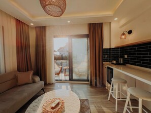 Una sala de estar moderna con un sofá, una mesa de centro y una zona de cocina con un taburete de bar.
