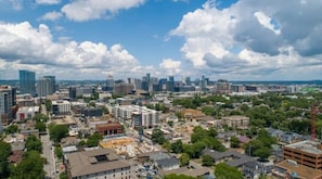 A cityscape with a mix of modern and older buildings, a clear sky, and a construction site in the foreground.