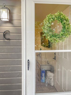 A door with a 'NO SMOKING' sign, a metal handle, and a wreath.