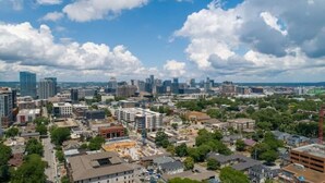 A cityscape with a mix of modern and older buildings, a clear sky, and a construction site in the foreground. - 2 BR Haven on Music Row - 8 Min to Downtown - Free Parking - Walkable to Eats -C (Nashville)