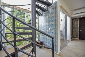 A spiral staircase with a metal railing leading to a glass door.