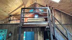 A wooden interior with a loft bed and a staircase. - Cozy Cabin with Sauna & Firepit! (Monroe)